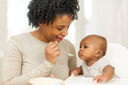 mom feeding baby solids for post on feeding your baby